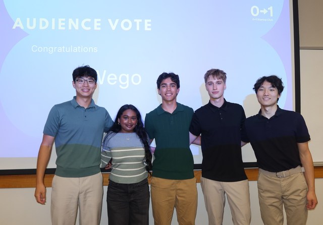 Evan and four teammates in front of a screen announcing their team, Wego, as the Audience Vote winner at the 0-1 Startup Club hackathon