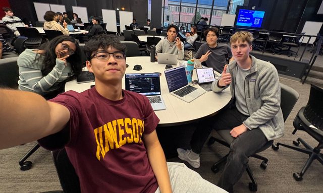 Group selfie of Evan and teammates around laptops at the 0-1 Startup Club hackathon kickoff at the University of Minnesota